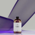 Bottle of perfume base with a white label on a gradient background